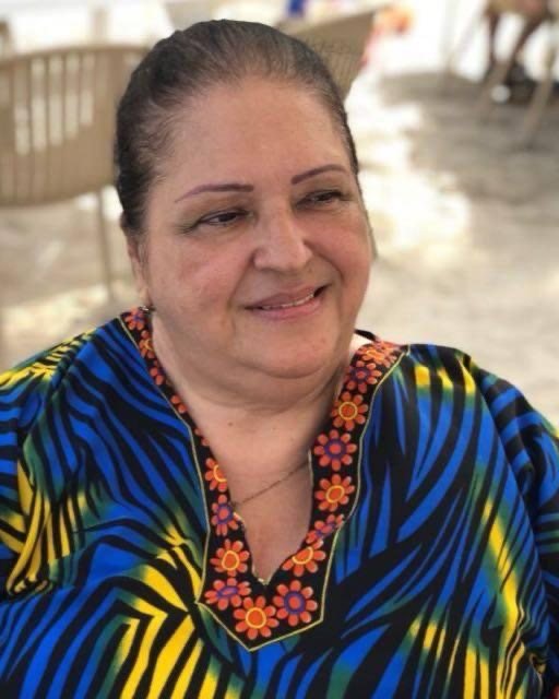 Primer plano de Ivonne Handal sonriendo, con una túnica de colores
